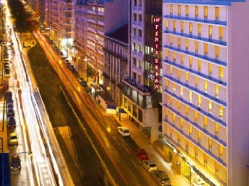 Stadtstraße bei Nacht mit langen Lichtstreifen und beleuchteten Gebäuden auf beiden Seiten.