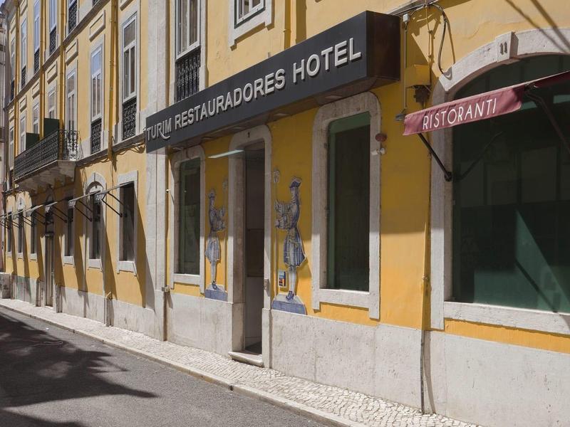 Yellow hotel building on a quiet, sunny street view.