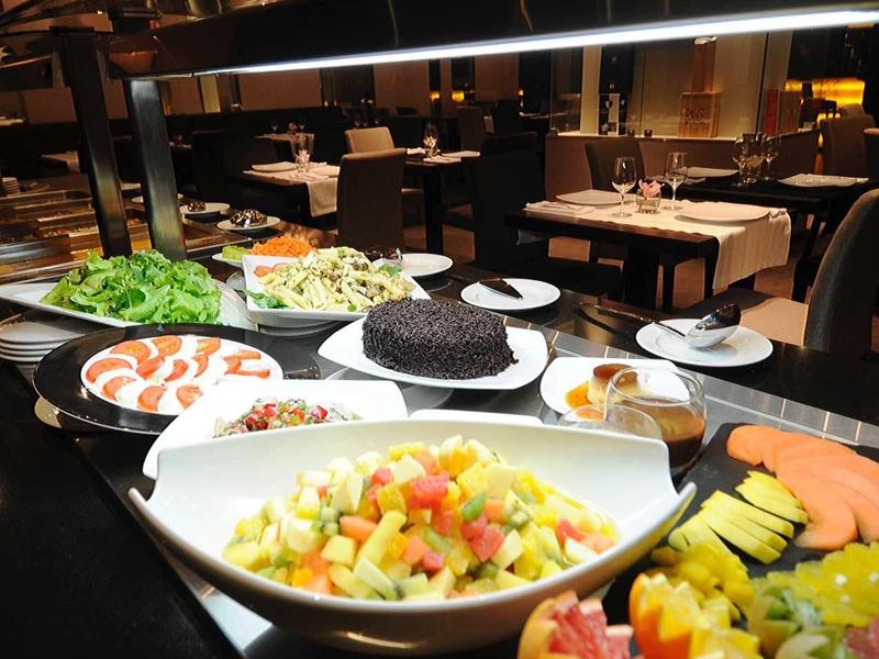 Buffet with various salads and fruits in a stylish restaurant.