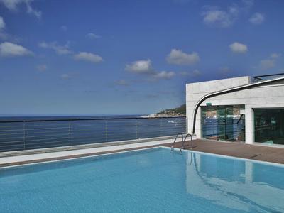 Modern zwembad met zeezicht en een heldere blauwe lucht op een zonnige dag