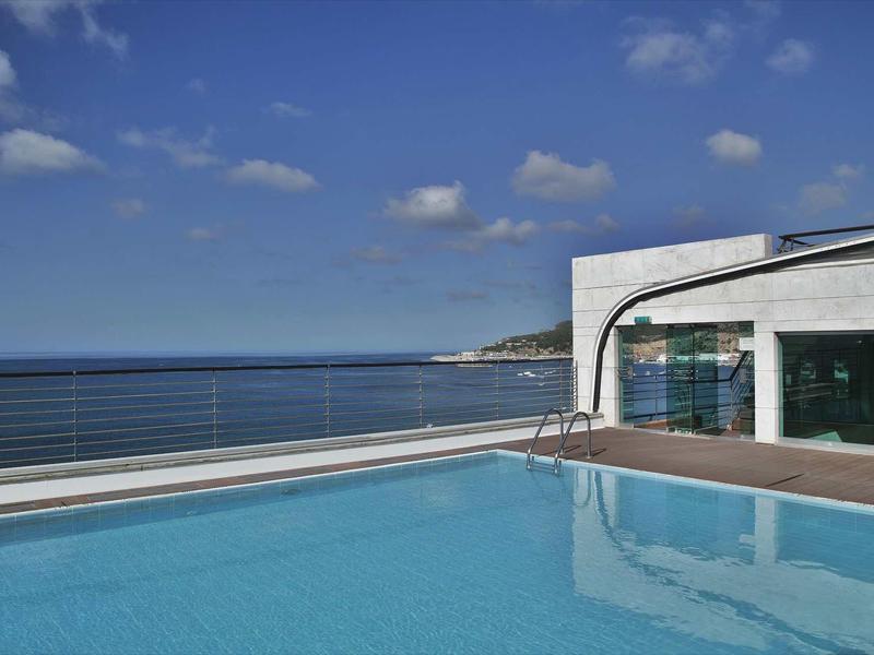 Modern zwembad met zeezicht en een heldere blauwe lucht op een zonnige dag