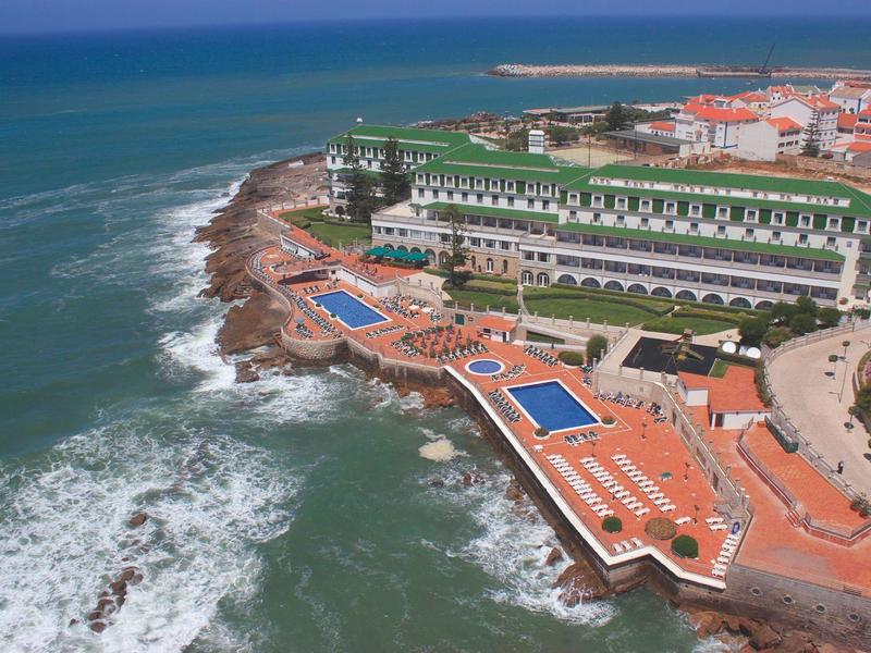 Hotel u moře s venkovními bazény a výhledem na rozbouřené oceánské vlny.