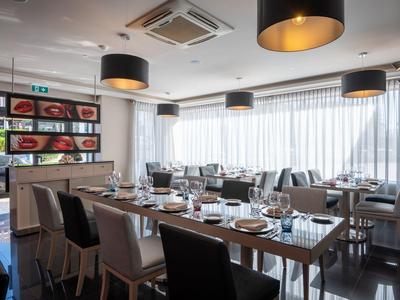 Restaurante elegante con mesas preparadas y lámparas colgantes modernas en un hotel.