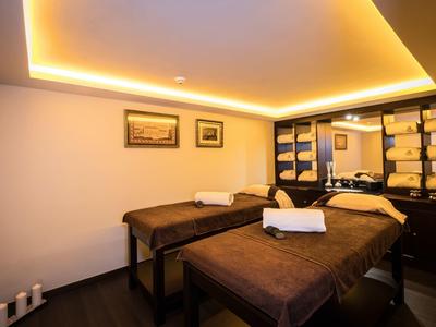 Sala de spa tranquila con dos camillas de masaje y luz cálida y suave.