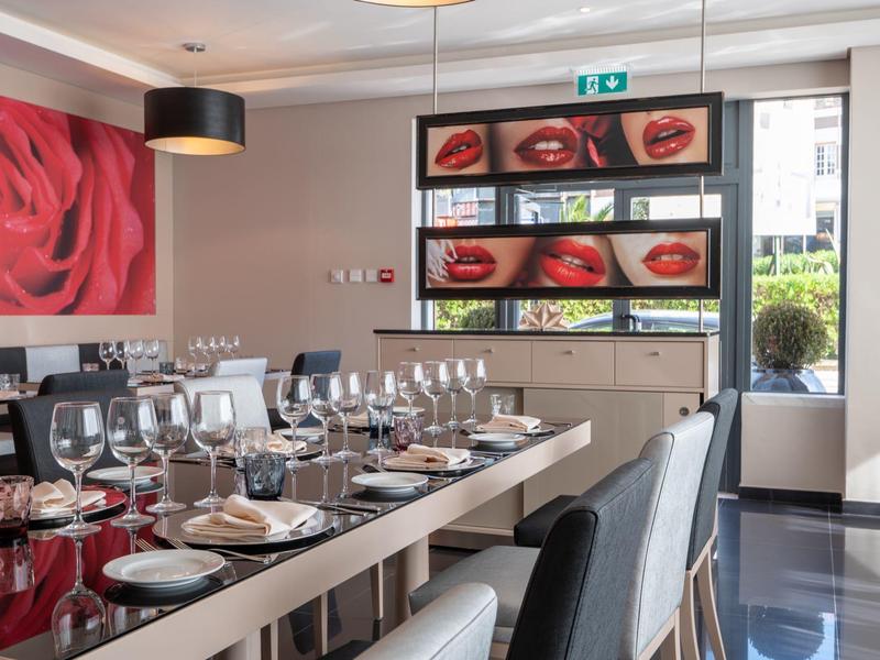 Comedor moderno con mesa elegantemente puesta y gran imagen de rosa en la pared.
