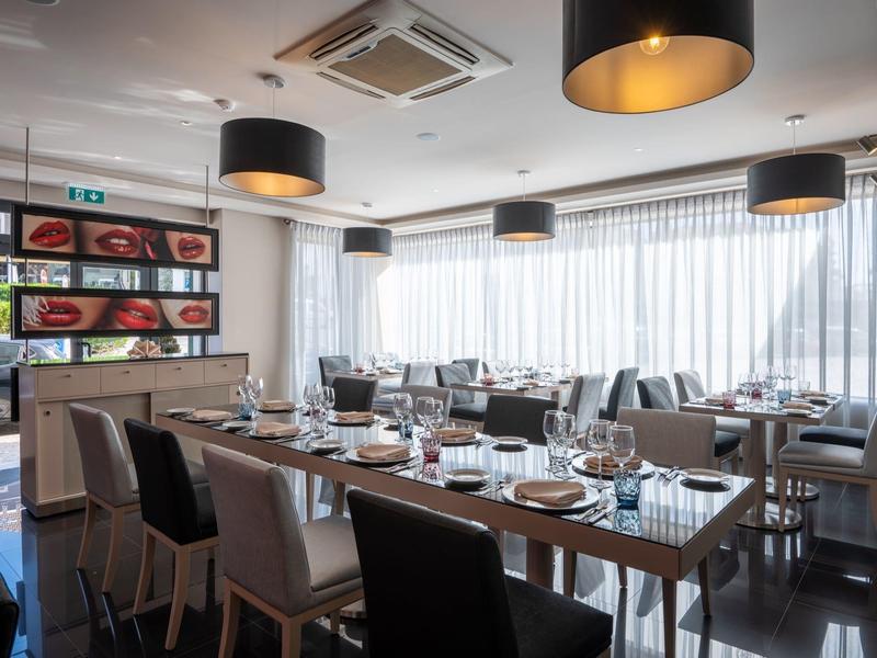 Restaurante elegante con mesas preparadas y lámparas colgantes modernas en un hotel.