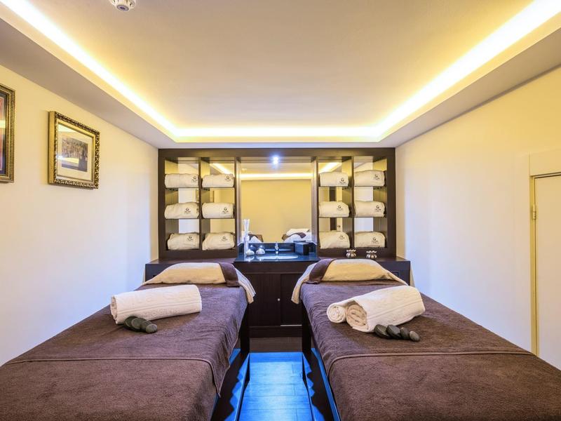 Dos camas de tratamiento cómodas en una sala de bienestar moderna y bien iluminada.