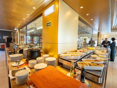 Buffet con piatti caldi e stoviglie in un ristorante moderno.