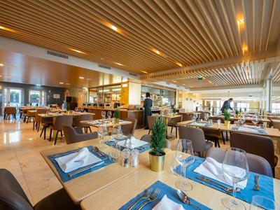 Ristorante d'hotel elegante con design moderno e tavoli apparecchiati.