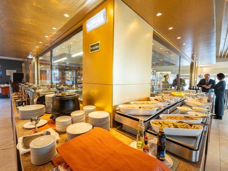 Buffet con piatti caldi e stoviglie in un ristorante moderno.