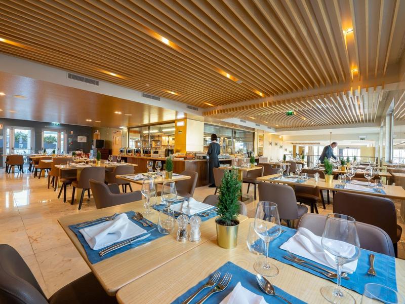 Ristorante d'hotel elegante con design moderno e tavoli apparecchiati.