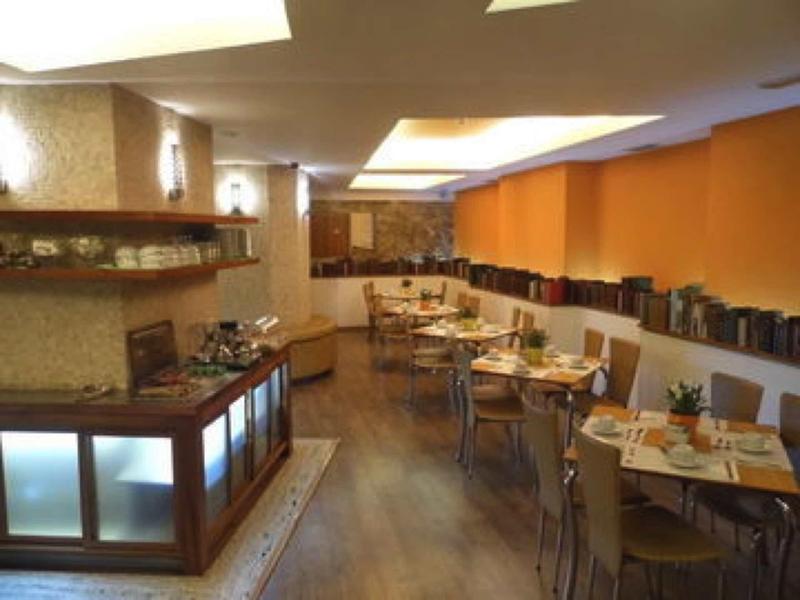 Accogliente ristorante dell'hotel con tavoli in legno, sedie e illuminazione calda.