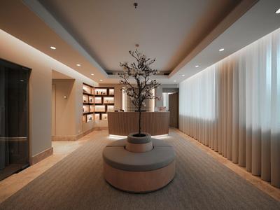 Jasne lobby hotelowe z okrągłą ławką, nowoczesnymi półkami i minimalistyczną dekoracją.