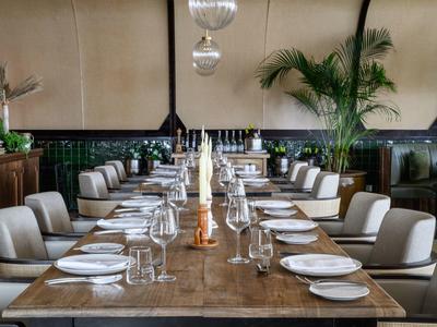 Elegancki stół w restauracji z białymi krzesłami i nakrytymi talerzami.