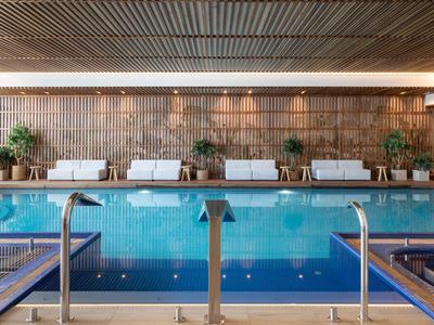 Moderner Innenpool mit Liegestühlen und Pflanzen in einem Hotel