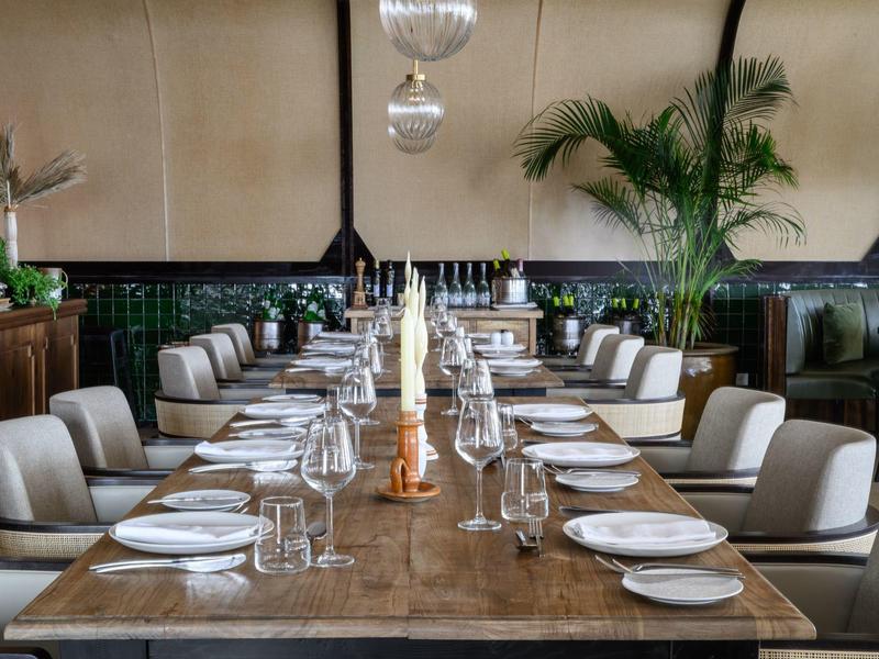 Elegancki stół w restauracji z białymi krzesłami i nakrytymi talerzami.