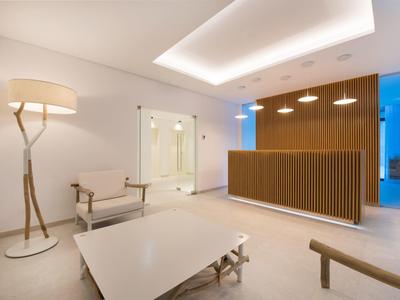 Modern hotel lobby with wooden reception desk, comfortable chairs, and stylish lighting.