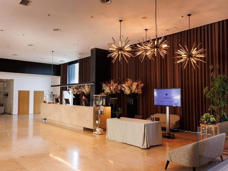 Modern hotel lobby with reception, decorative lights, and seating area