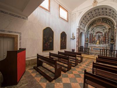 Malá kostelní loď s dřevěnými lavicemi, zdobenými oltáři a vysokými okny