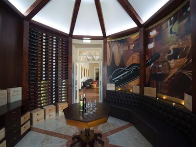 Elegantní vinný sklep s zaoblenou dřevěnou lavicí a regálem na lahve.