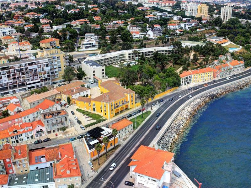 Město u moře s pobřežní cestou a barevnými budovami vedle hotelu.