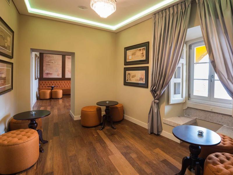 Elegantní čekárna s čalouněnými křesly, dřevěnou podlahou a závěsy v interiéru hotelu.