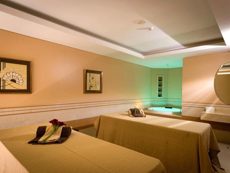 Klidný spa prostor se dvěma masážními lůžky a tlumeným osvětlením.