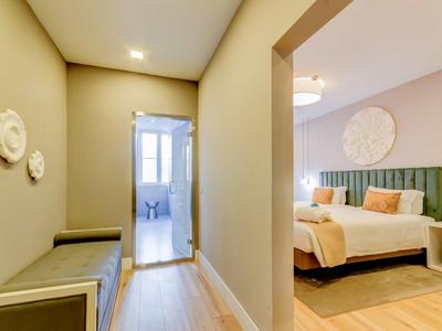 Corridoio con pavimento in legno che conduce a camera da letto e bagno.