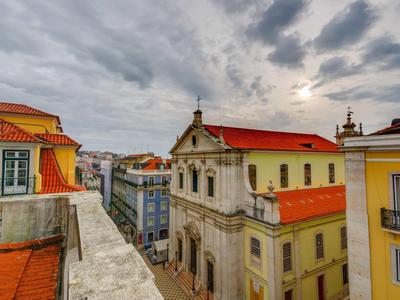 Vista di edifici storici con tetti rossi sotto un cielo nuvoloso.