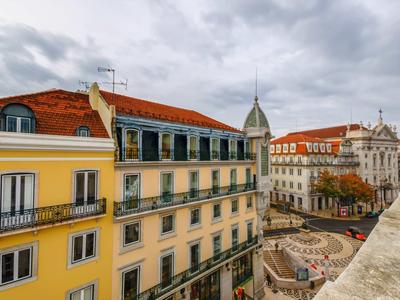 Vista sulla città con edifici gialli, piazza lastricata e cielo nuvoloso