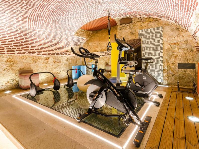 Palestra moderna con attrezzi per esercizi in una cantina a volta in mattoni.