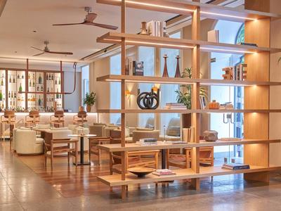 Helles, modernes Restaurant mit Holzregal, weißen Stühlen und warmen Beleuchtungen.