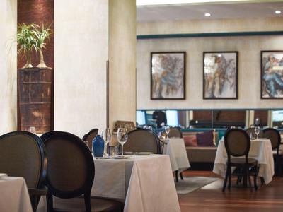 Elegant restaurant with set tables and artwork on the walls in a hotel