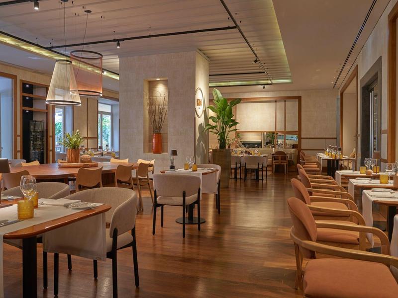 Elegant restaurant with warm wooden flooring and cozy seating arrangements.