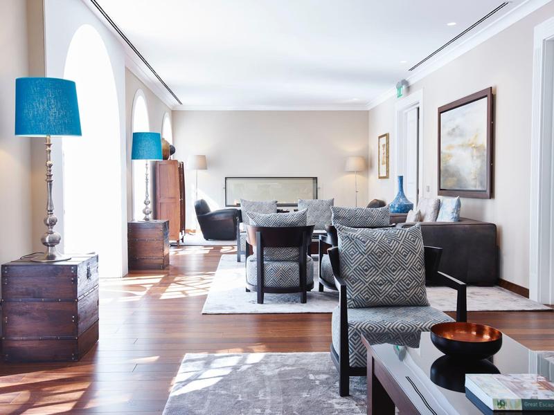 Bright living room with modern furniture, large windows, and blue lamps.