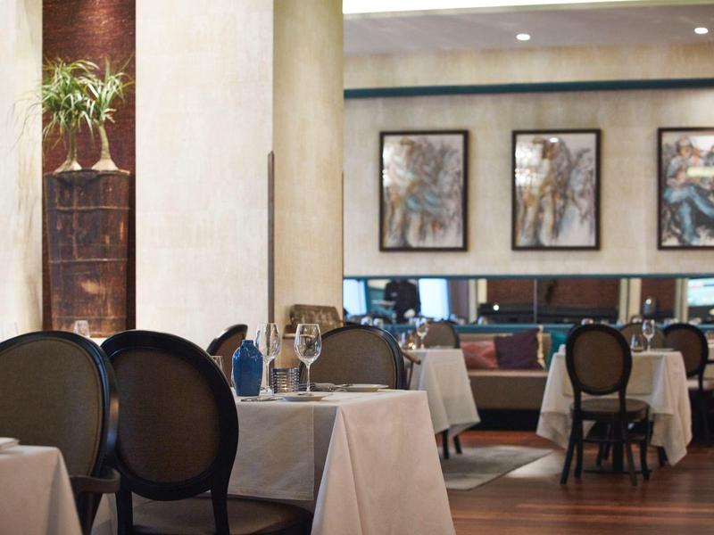 Elegant restaurant with set tables and artwork on the walls in a hotel