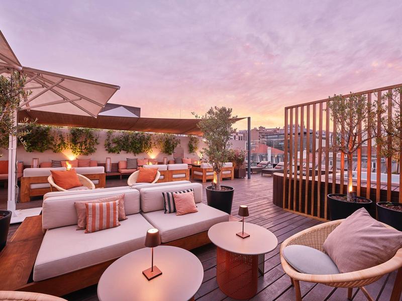 Rooftop terrace with modern seating and pink evening sky