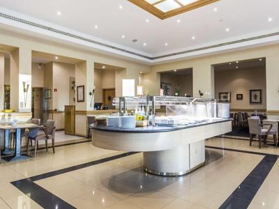 Elegante sala de desayuno con iluminación moderna y mesas puestas en ambiente claro