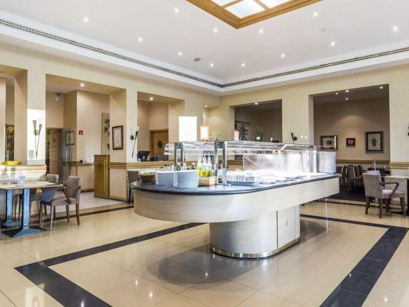 Elegante sala de desayuno con iluminación moderna y mesas puestas en ambiente claro