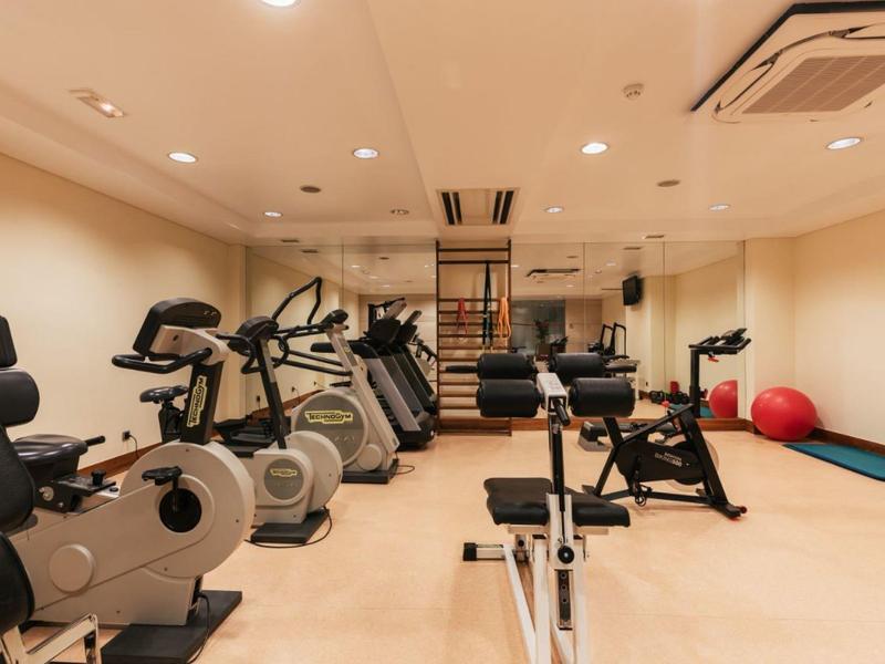 Modern gym with various exercise machines and bright interior.