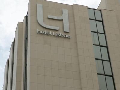 Edificio alto con grande logo dell'hotel in alto contro cielo nuvoloso