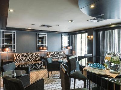 Area lounge elegante dell'hotel con sedute di design e illuminazione delicata.