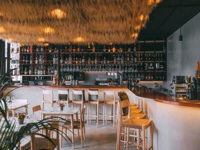 Area bar moderna in hotel con sgabelli in legno di alta qualità e ampia selezione di bevande.