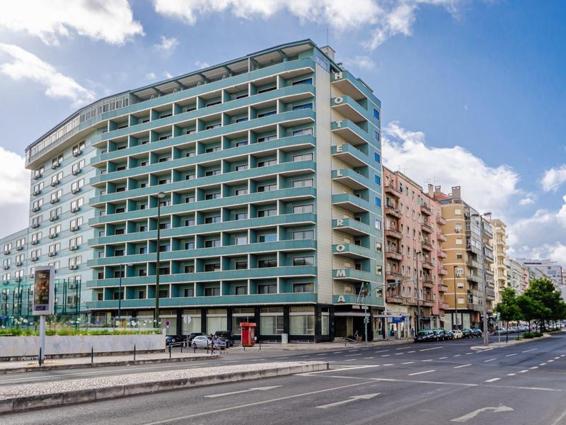Edificio alberghiero moderno su più piani su una strada tranquilla durante il giorno.