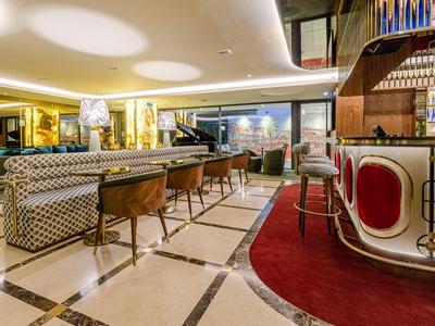 Elegante hall dell'hotel con bar, posti a sedere e grande finestra con vista sulla città