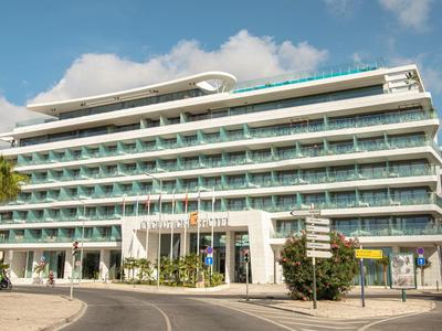 Nowoczesny hotel z wieloma piętrami i balkonami pod niebieskim niebem.