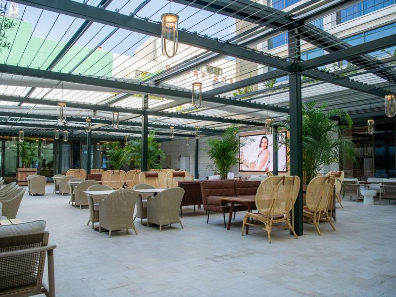 Nowoczesne wejście z miejscami do siedzenia i szklanym dachem w hotelu.