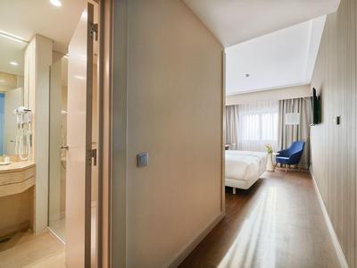 Moderner Hotelzimmerflur mit Bad links und Schlafzimmer am Ende des Flurs.