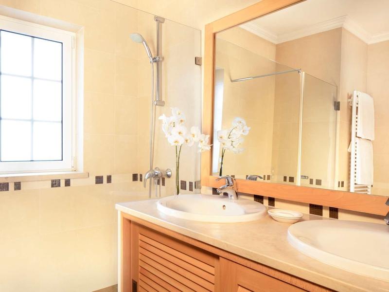 Bagno luminoso con doppio lavabo, grande specchio e finestra.