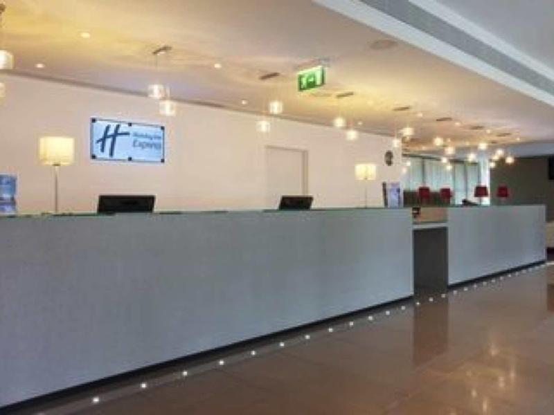 Reception moderna dell'hotel con un lungo banco e un'atmosfera luminosa.